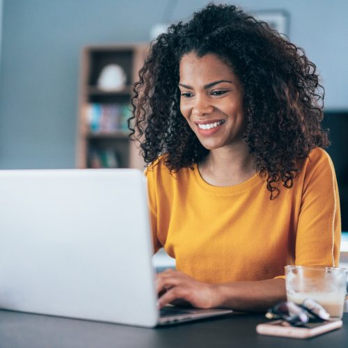 Young modern woman working from home, using laptop